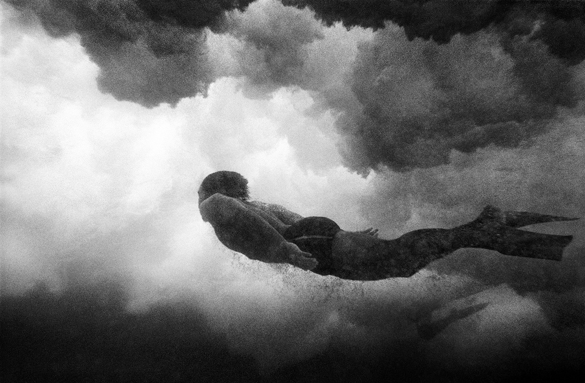 A freediver rises through the foam